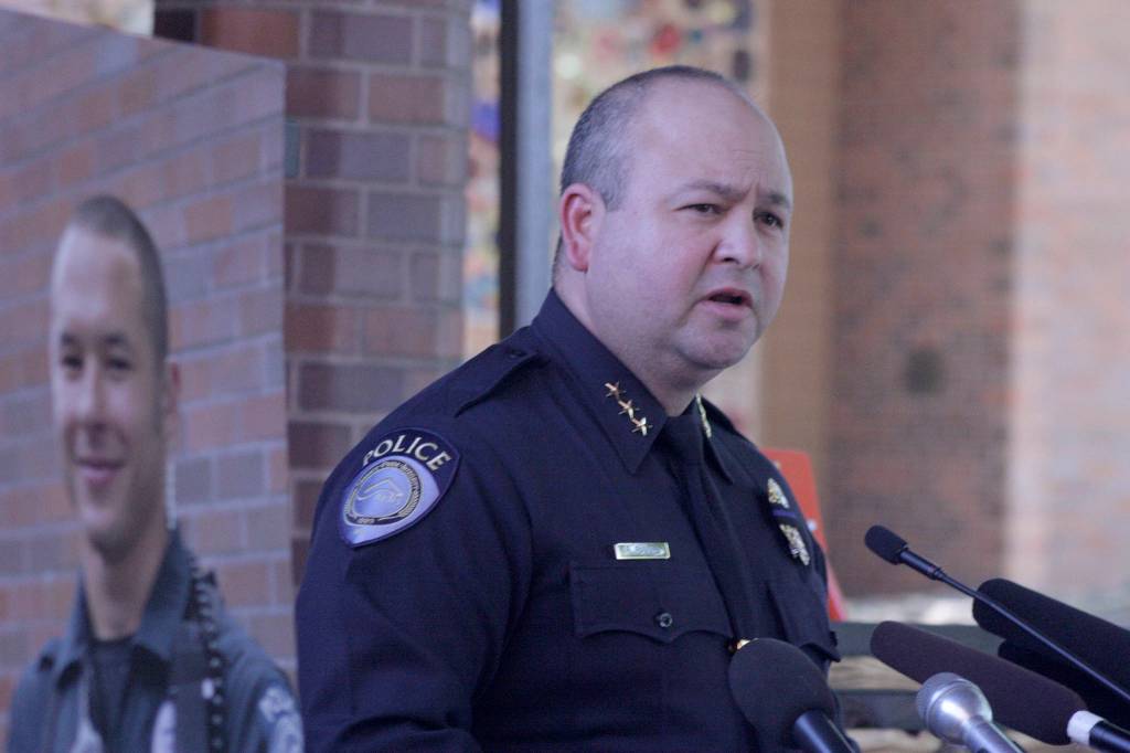 Kent Police Chief Rafael Padilla delivers an update on the investigation and death of officer Diego Moreno, shown left on a poster, at a press conference Monday afternoon outside police headquarters. MARK KLAAS, Kent Reporter