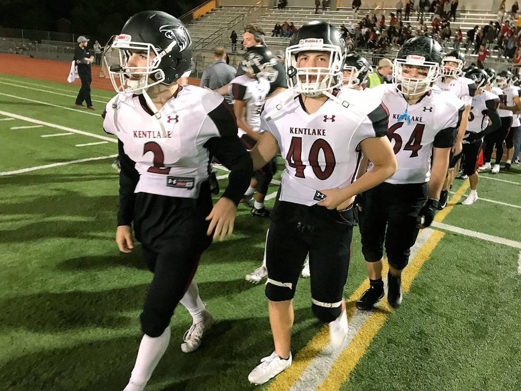 Kentlakes Hudson Potts, left, and Nathaniel Madrid walk onto the field following the Falcons 42-20 NPSL victory against the Trojans at Auburn Memorial Stadium on Thursday night. MARK KLAAS, Kent Reporter