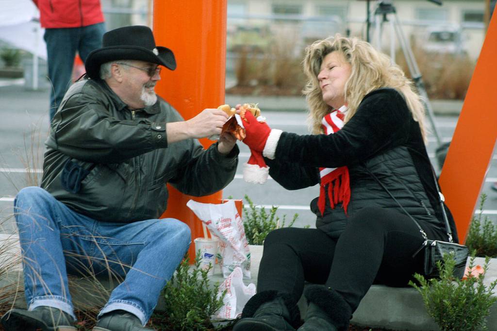 Ed Covello and LaRee Lewis enjoy a meal under the Dicks Drive-In sign during the grand opening Wednesday morning at the new Kent location on Pacific Highway South. STEVE HUNTER, Kent Reporter