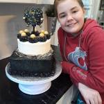 Image courtesy Cory Crawford                                Micah Crawford, 12, shows off a New Years cake she made for a customer, complete with a chocolate square base with chocolate buttercream and a vanilla top with strawberry buttercream filling.