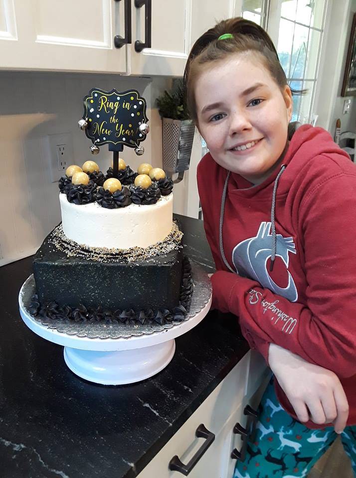 Image courtesy Cory Crawford                                Micah Crawford, 12, shows off a New Years cake she made for a customer, complete with a chocolate square base with chocolate buttercream and a vanilla top with strawberry buttercream filling.