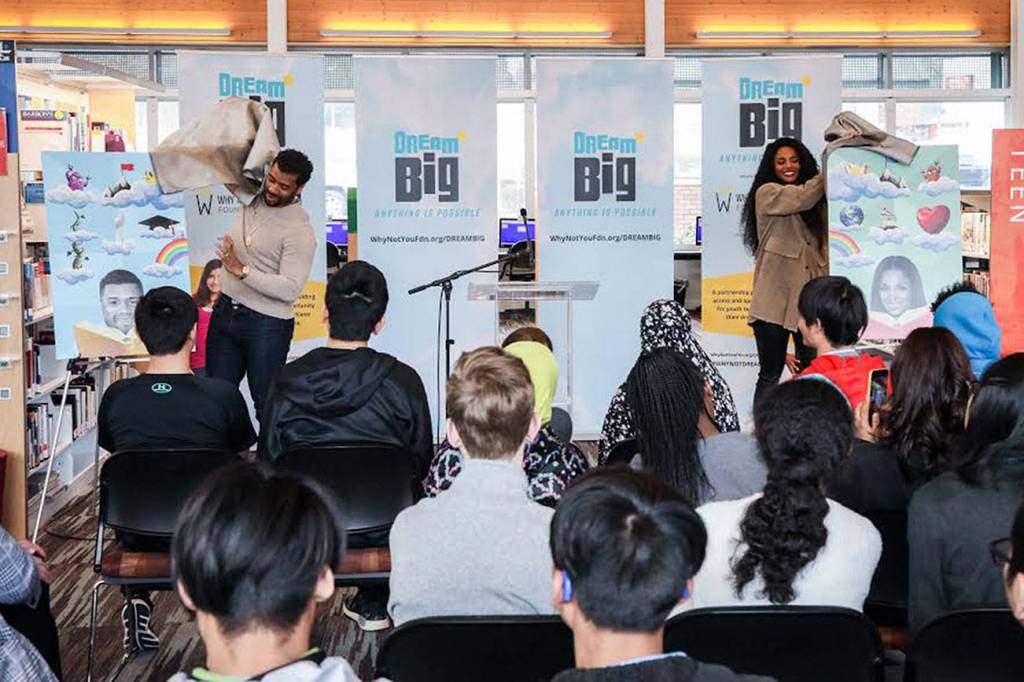 Russell Wilson and Ciara unveil the limited edition King County System Library cards that feature them and their dreams Friday at the Tukwila Library. The new library cards coincide with the newly launched DREAM BIG: Anything is Possible campaign. Courtesy photo by Why Not You Foundation