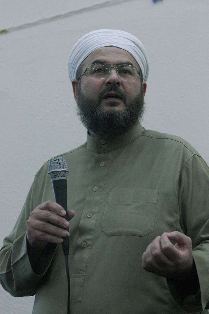 Shaykh Imad Al Busaad, imam of the Kent Islamic Center, speaks at a joint interfaith vigil and community gathering at the centers gym Friday night. Al Busaad urged people of all faiths to come together and strive for peace in an era of Islamophobia. MARK KLAAS, Kent Reporter