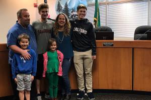 Jennifer Harjehausen poses with her family next to her new nameplate in Covington City Hall on April 11 during her swearing in. Photo by Kayse Angel