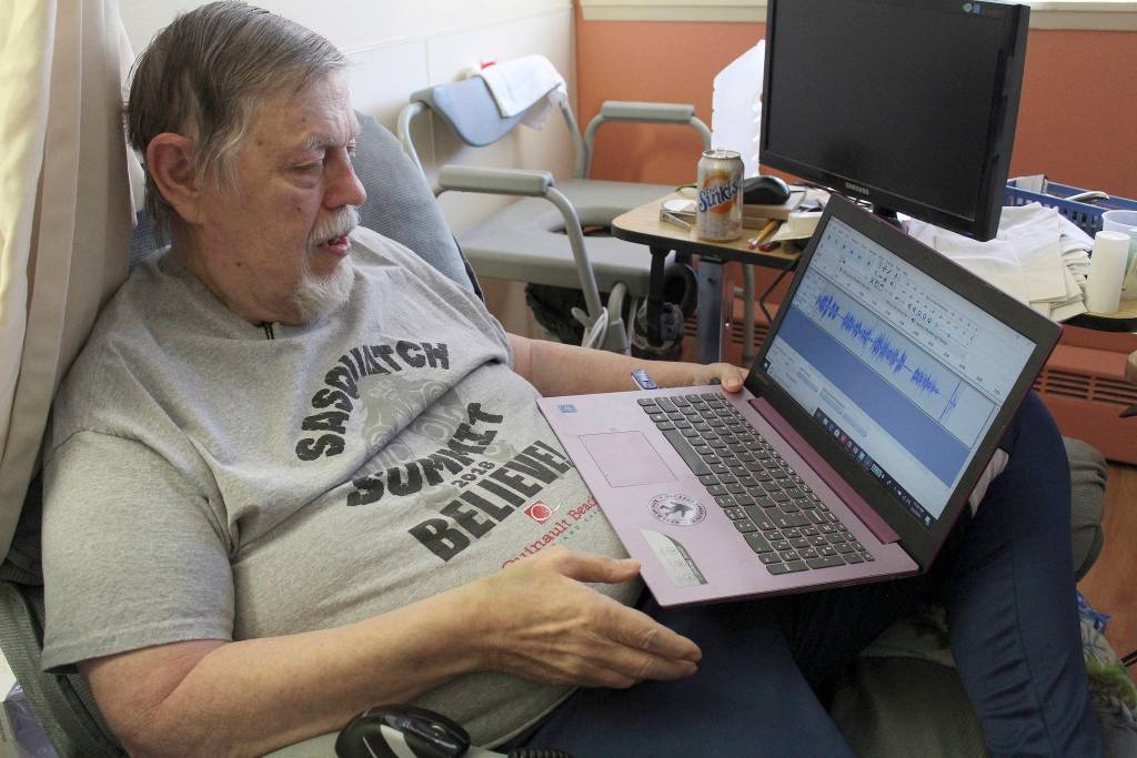 Thom Cantrell, one of the organizers of the upcoming International Conference for Primal People, listens to a 1970s recording, known as the Sierra Sounds, which many Sasquatch believers claim is two Sasquatches having a conversation. One of the recorders, Ron Morehead, will be a speaker at the event on Saturday, April 27. Photo by Ray Miller-Still