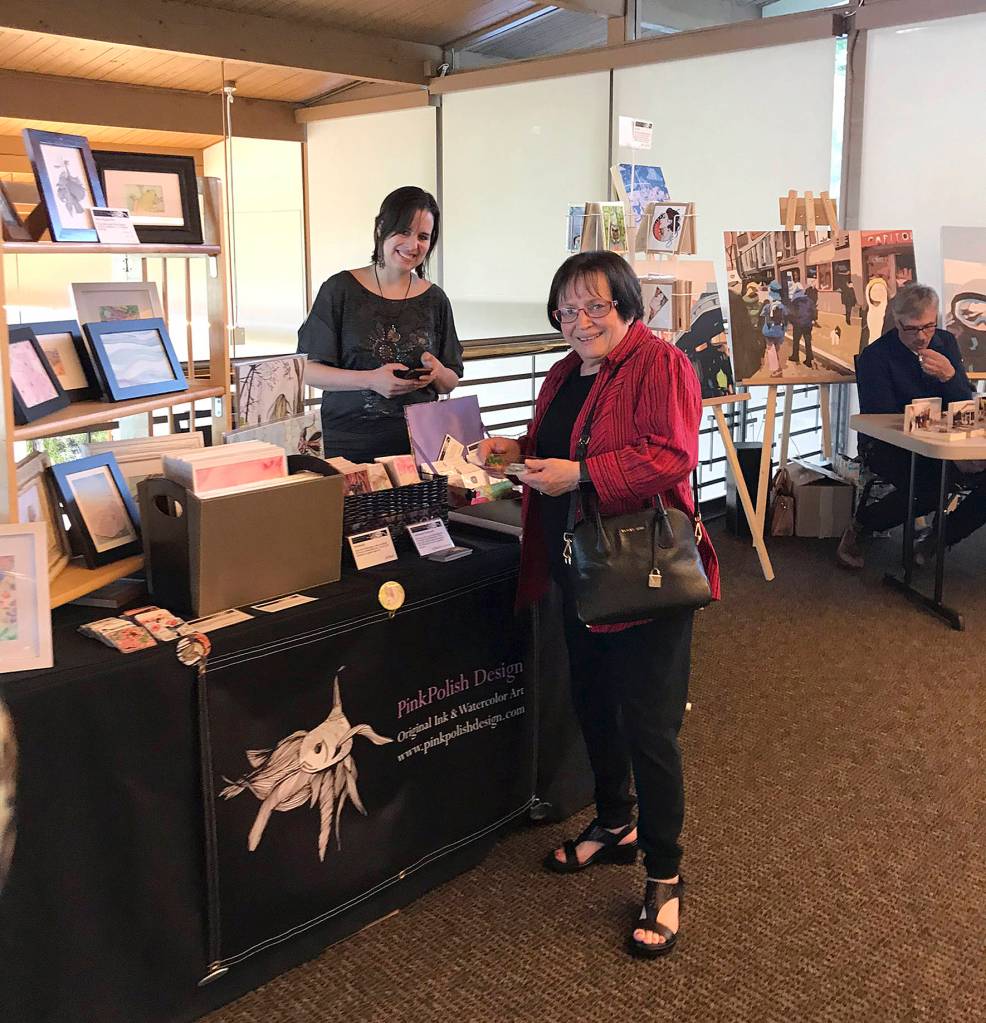 Photo by Kayse Angel                                 Councilmember Linda Olson checks out artist Katie Harmons work during the Lake Wilderness Lodge Art Exhibition Grand Opening on May 8.