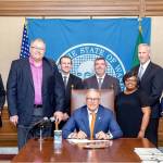 Photo pulled from city of Covington Facebook                                 Covington Mayor Jeff Wagner and City Manager Regan Bolli visit Gov. Jay Inslee on may 9 while Inslee signed HB 1366.