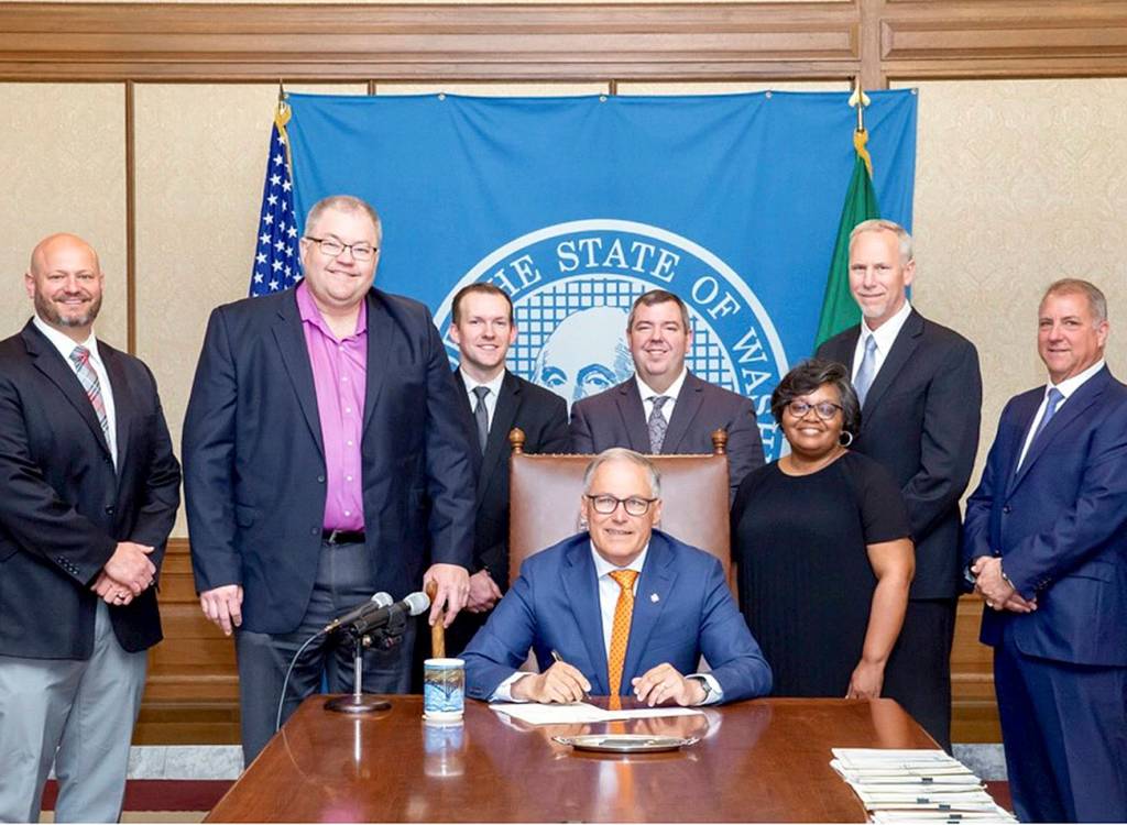 Photo pulled from city of Covington Facebook                                 Covington Mayor Jeff Wagner and City Manager Regan Bolli visit Gov. Jay Inslee on may 9 while Inslee signed HB 1366.