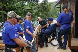 Photo courtesy of Building Beyond the Walls                                 Building Beyond the Walls volunteers building Terry Hildebrands ramp alongside his family.