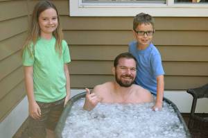 Justin Gielski, an American Ninja Warrior contestant, sits in an ice bath after a workout. With him are his two children, Sophie, 9, and Axel 8. COURTESY PHOTO
