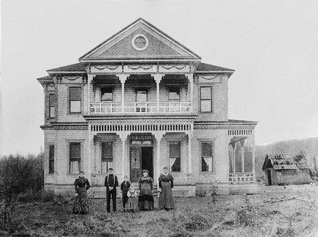 The family of Aaron, Sr. and Sarah Neely pose in front of their new Green River Valley home, east of Auburn, mid-1890s. The young boy, third from left, appears to be Aaron Neely, Jr., father of Howard Elliot Neely (see 2010 photo); Sarah Graham Neely, wife of Aaron, Sr., is on the far right. Courtesy Neely Mansion Association.