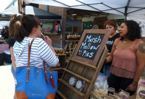 Community members takes samples at one of the stands at the Maple Valley Farmers Market.