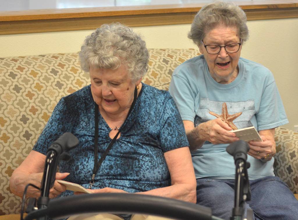 Seniors from Fountain Court Senior Living in Maple Valley admire the painted tiles they received from Shadow Lake Elementary School students on June 13.