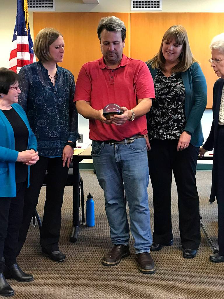 Photo by Kayse Angel                                 Brett Habenicht and Maple Valley staff members admires his Golden Maple Leaf Award that was given to him during the May 28 Special Council Meeting.