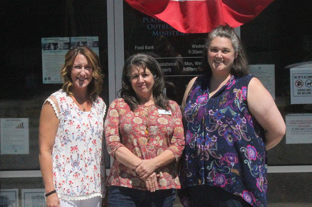 Photo by Danielle Chastaine                                  From left to right: Plateau Outreach Ministries Director Elaine Olson, Outreach Case Manager for Veterans and Seniors Lisa Napolitano, and Director Elisha Smith-Marshall stand outside of their nonprofits office. The trio work together regularly to help lift up the vulnerable populations in Enumclaw, Black Diamond and Covington.