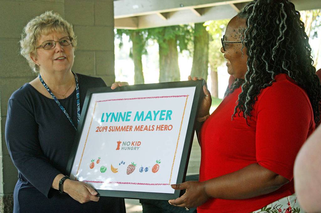 MARK KLAAS, Kent Reporter                                 State Rep. Debra Entenman, D-Covington, right, presents the No Kid Hungrys 2019 Summer Meals Hero award to Kent School Districts Lynne Mayer during an impromptu ceremony Thursday at Lake Meridian Park.