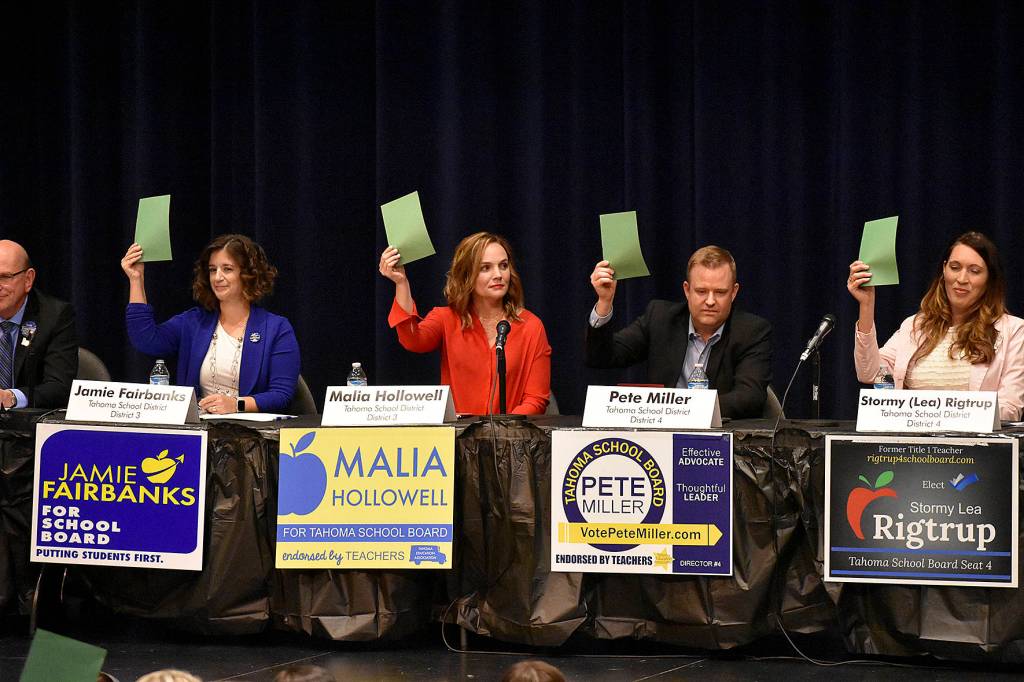 Photo by Haley Ausbun. One segment of the Maple Valley Candidate forum, Oct. 17 at Tahoma High School, included asking candidates yes or no questions by raising a red or green card. All School district candidates, Jamie Fairbanks, Malia Hollowell, Pete Miller and Stormy Rigtrup, raised a card to indicate yes on a question.