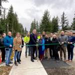Covington Mayor Jeff Wagner cuts the ribbon on the completed 164th Avenue Southeast Pedestrian Improvement Project on Thursday, Jan. 9, surrounded by city officials.                                Photo courtesy of the City of Covington.