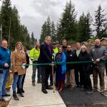 Covington Mayor Jeff Wagner cuts the ribbon on the completed 164th Avenue Southeast Pedestrian Improvement Project on Thursday, Jan. 9, surrounded by city officials.                                Photo courtesy of the City of Covington.