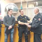 Covington Police officers Branson Carr, left, and Jordan Hess, right, were honored by Captain Joe Root of the Puget Sound Regional Fire Authority for their efforts in saving resident Debra Stevens life during the Monday, Jan. 27, 2020, city council meeting. Photo by Danielle Chastaine.