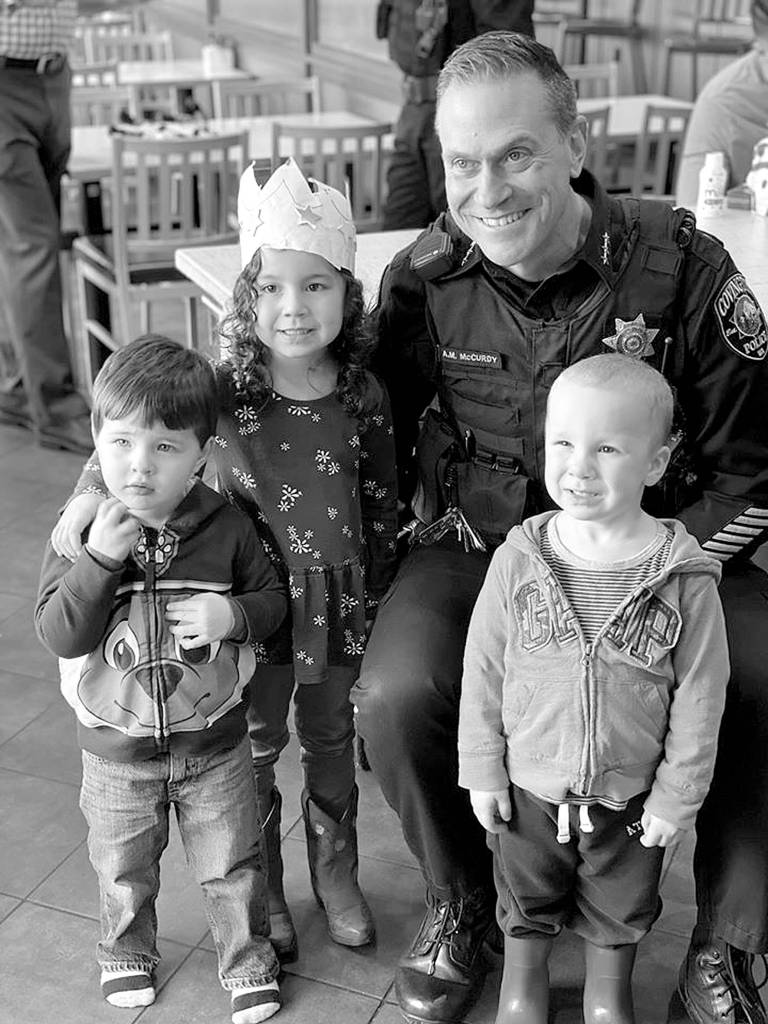 Covington Police Chief Andrew McCurdy stands with three Covington kids for a photo during the Coffee with a Cop event at the Covington Chick-fil-A on Monday, Feb. 10, 2020. Photo courtesy of the City of Covington.