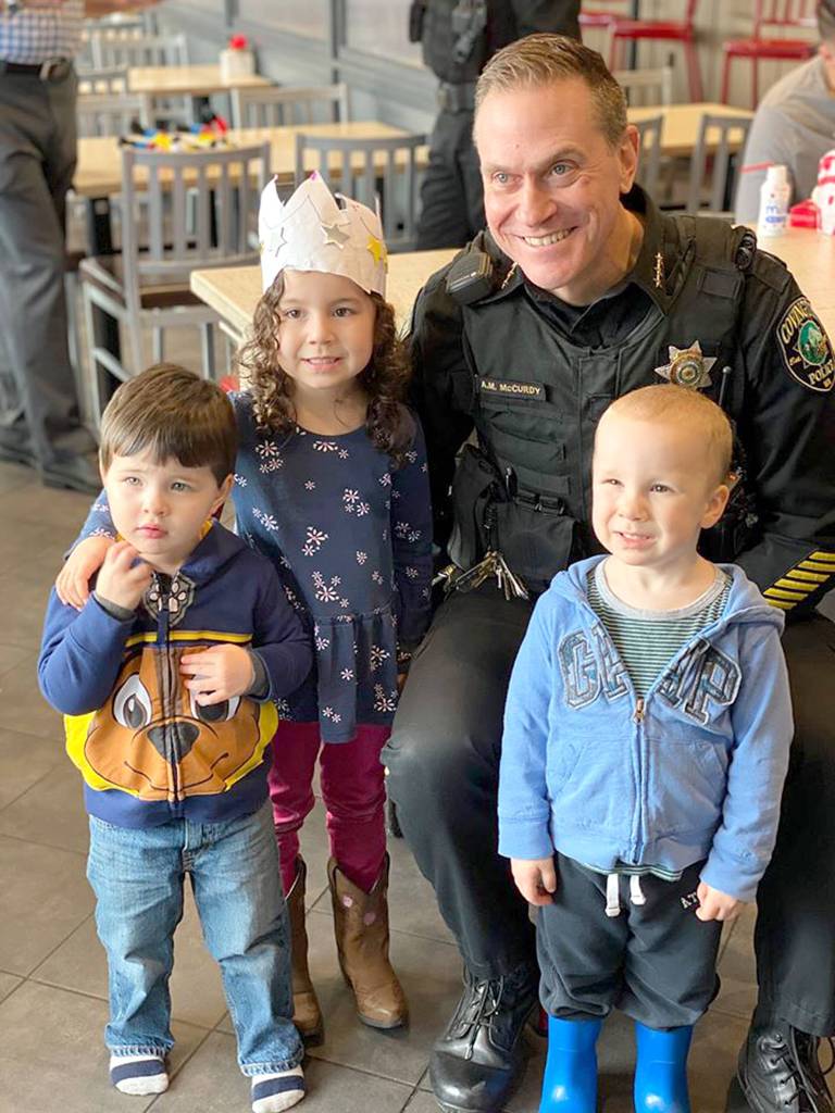 Covington Police Chief Andrew McCurdy stands with three Covington kids for a photo during the Coffee with a Cop event at the Covington Chick-fil-A on Monday, Feb. 10, 2020. Photo courtesy of the City of Covington.