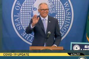 Gov. Jay Inslee waves during his Thursday morning press conference on extending protections for renters. (TVW)