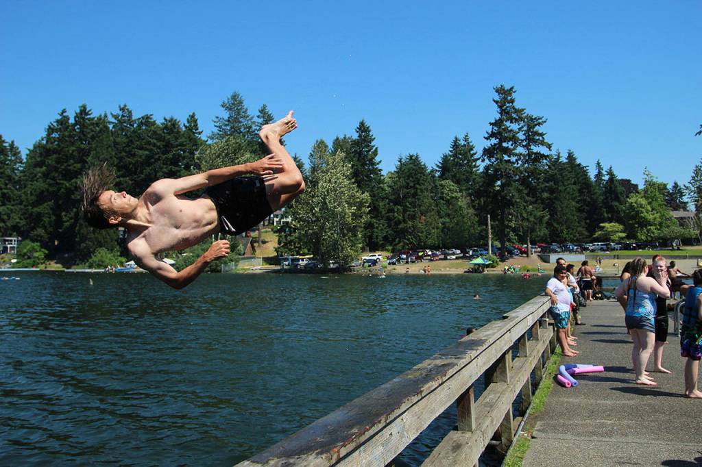 Fedor Osipov, 15, flips into Steel Lake in Federal Way during last year's heatwave on June 28, 2021. Olivia Sullivan/Sound Publishing