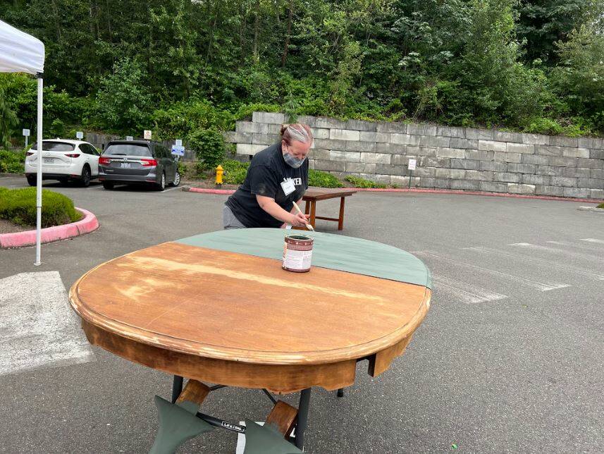 Angela Bayler painting a table at the Furniture Fix-it Fair. Photo courtesy of Xenia Dolovova.