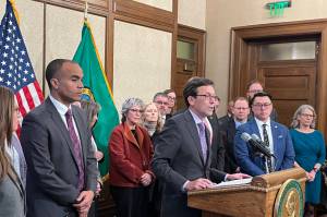 Gov. Bob Ferguson, surrounded by other state elected leaders, speaks at a Feb. 13 press conference in Olympia. (Photo by Bill Lucia/Washington State Standard)