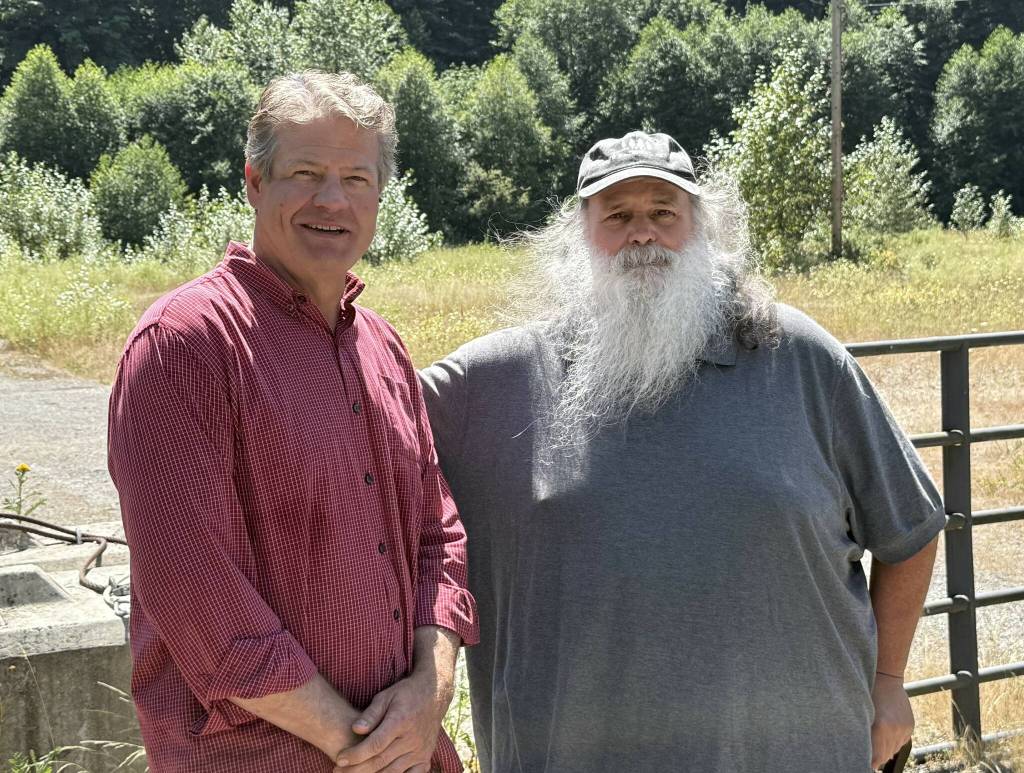 King County Council Vice Chair Reagan Dunn (left) and Bob Baker of Save the Cedar River (right) stand in front of the lot that will no longer be the site of an asphalt plant near the Cedar River. Photo by Drew Dotson/Renton Reporter