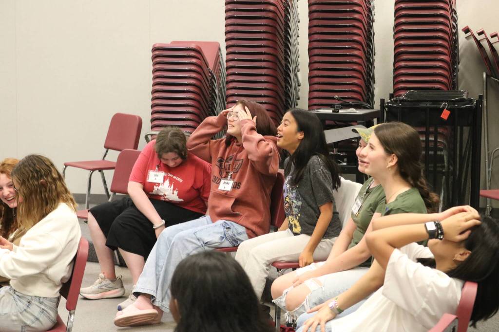 Colla Voce students cringe as their director shows them how to do the brat rot warm-up at the beginning of rehearsal. Photo by Bailey Jo Josie/Sound Publishing.