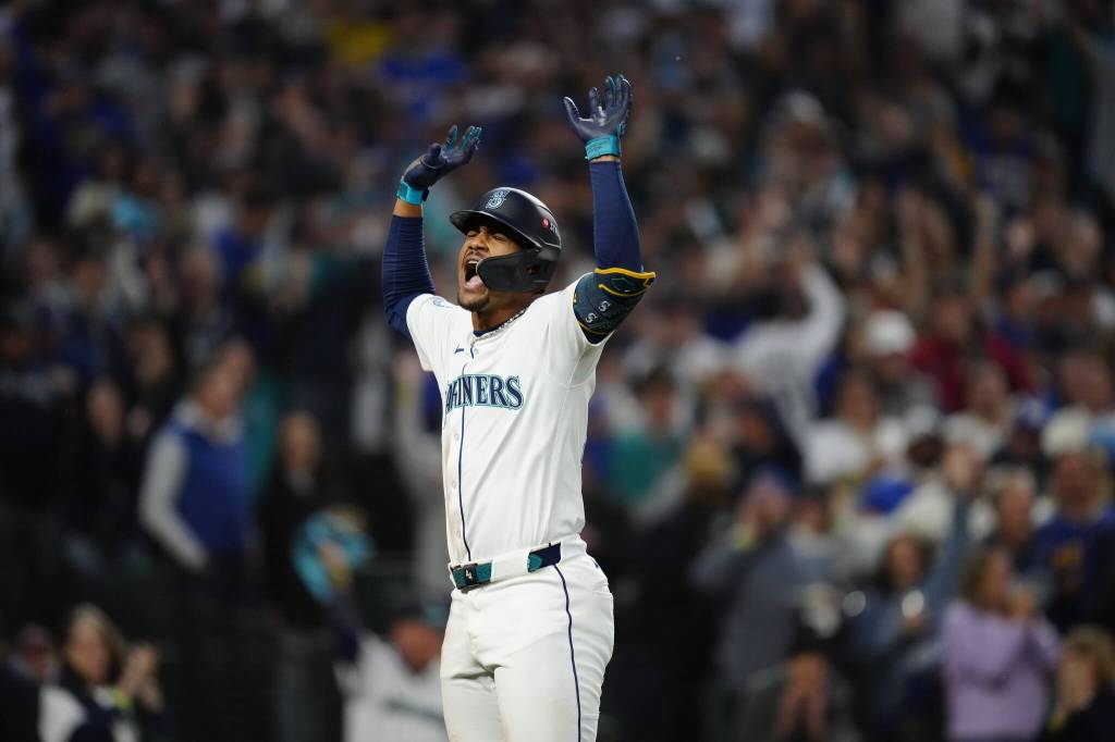 Julio Rodriguez raises his arms after scoring on a home run. Photo credit: Ben Van Houten / Seattle Mariners