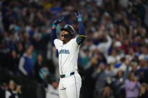 Julio Rodriguez raises his arms after scoring on a home run. Photo credit: Ben Van Houten / Seattle Mariners