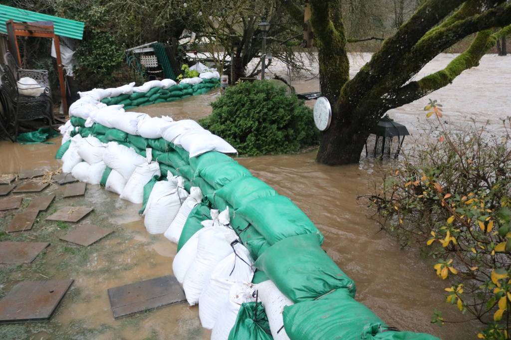 Neighbors and volunteers built a wall of sandbags to keep the water at bay outside the home of Jack Lyon, 94. Photo by Bailey Jo Josie/Sound Publishing