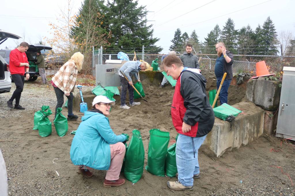 Maplewood residents and helpers fill up sandbag after sandbag at the county public sandbag station in the Highlands to keep the water from getting into their neighborhood on Dec. 11. Photo by Bailey Jo Josie/Sound Publishing.
