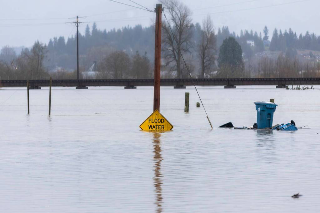 Floodwater from the Snohomish River partially covers a flood water sign on Thursday, Dec. 11, 2025 in Snohomish, Washington. (Sound Publishing photo)