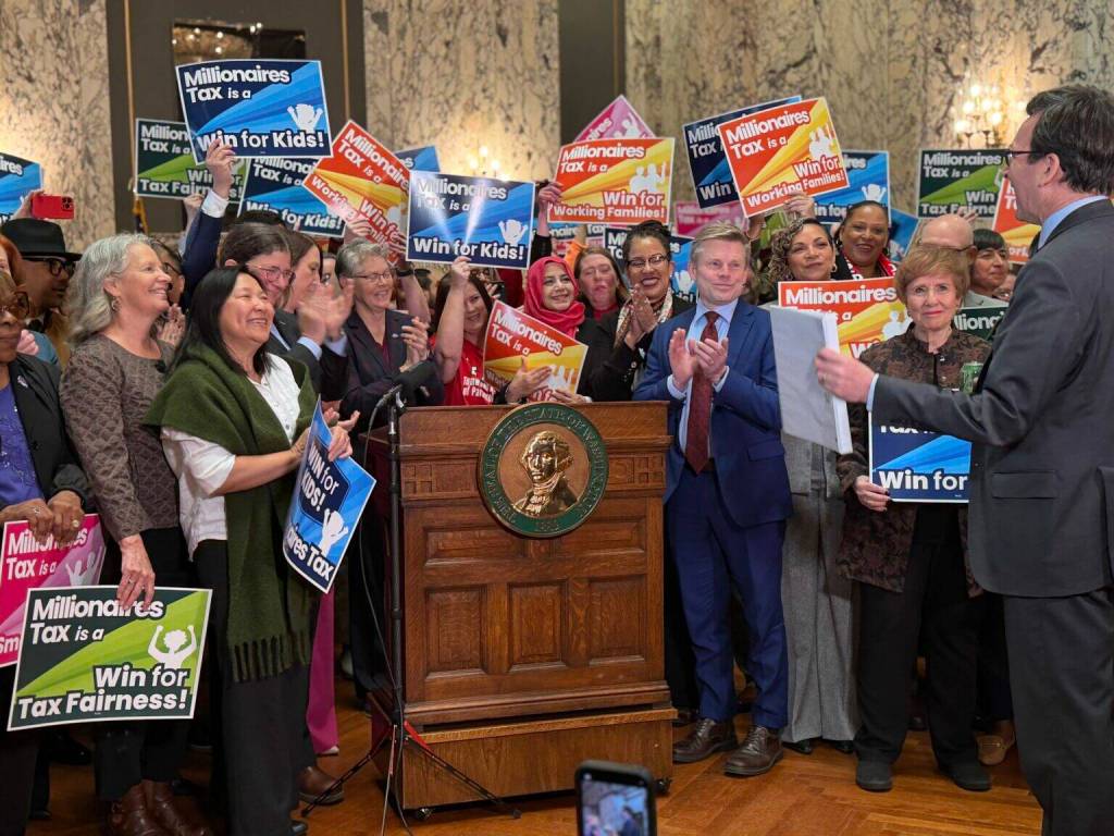 Supporters of Washingtons new income tax on millionaires celebrate as Gov. Bob Ferguson prepares to sign it on Monday, March 30, 2026, in Olympia. (Photo by Aspen Ford/Washington State Standard)