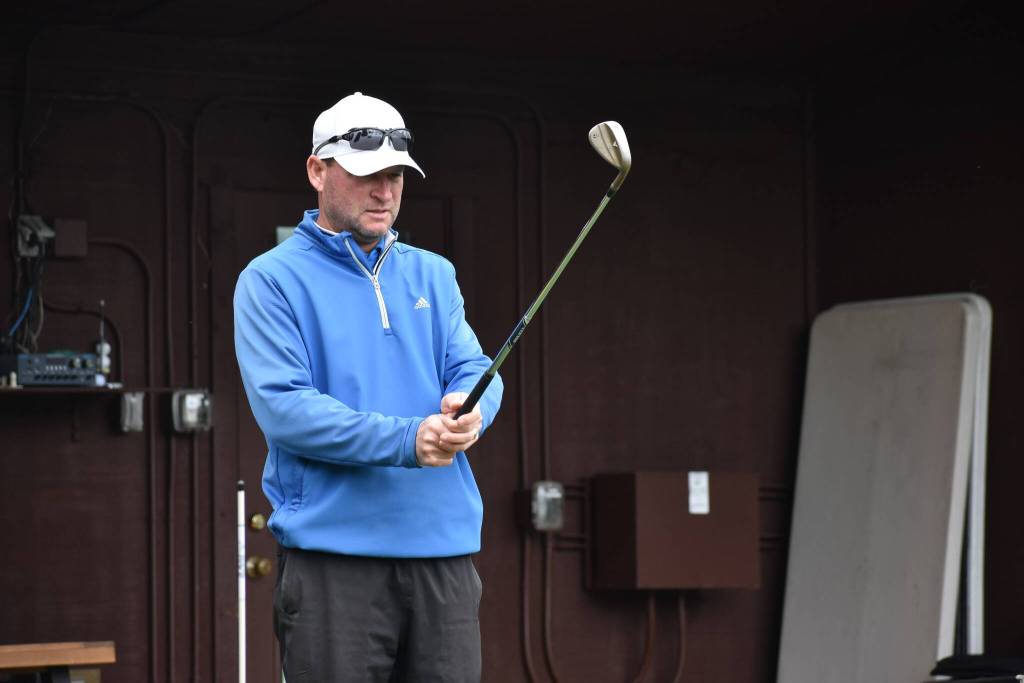 Brian Thornton eyes down the driving range during a lesson. Ben Ray /The Reporter